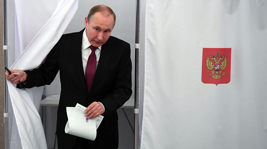 Действующий президент РФ, кандидат на пост президента РФ Владимир Путин во время голосования на выборах президента РФ на избирательном участке № 2151, 18 марта 2018 года