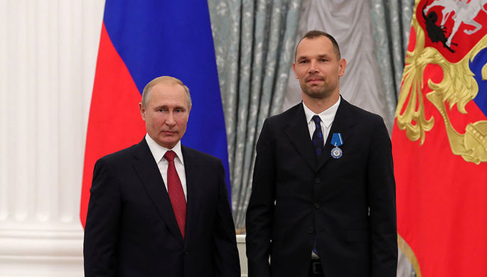 Владимир Путин и футболист национальной сборной Сергей Игнашевич (справа) на церемонии вручения в...