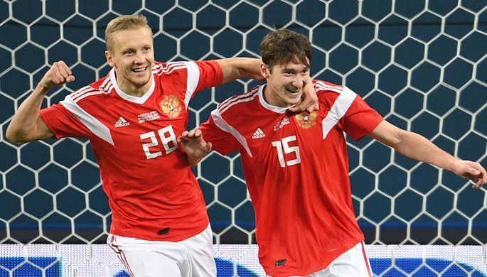 Игроки сборной России Игорь Смольников и Алексей Миранчук (справа) радуются забитому мячу в...