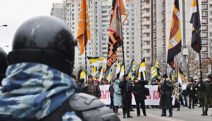 Сотрудник ОМОНа и участники акции «Русский марш» в Москве