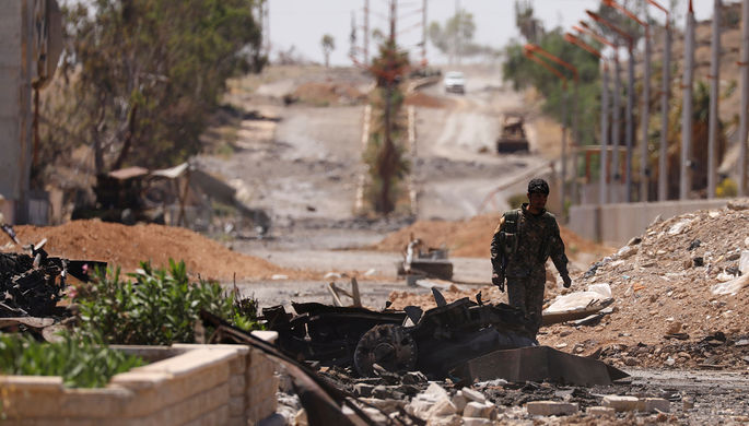 Ополченец «Демократических сил Сирии» (SDF) на улице отбитого у террористов сирийского города Табка...