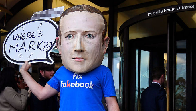 Активист в маске с изображением основателя Facebook Марка Цукерберга во время акции в Лондоне...