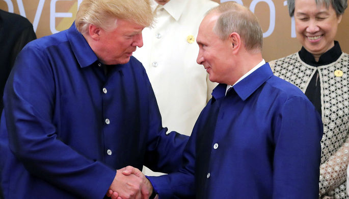 Президент США Дональд Трамп и президент России Владимир Путин пожимают руки во время встречи на...