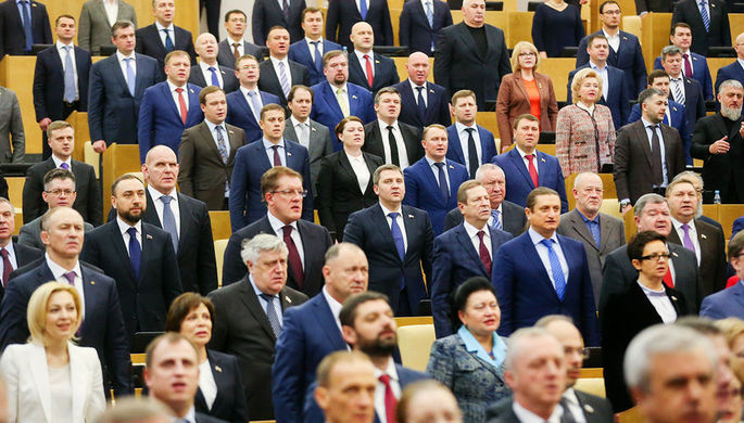 Депутаты во время исполнения государственного гимна на пленарном заседании Госдумы, декабрь 2017...