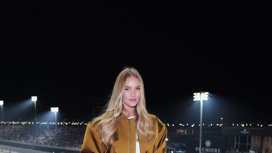 Модель Рози Хантингтон-Уайтли в золотом бомбере и брюках снялась на автогонках