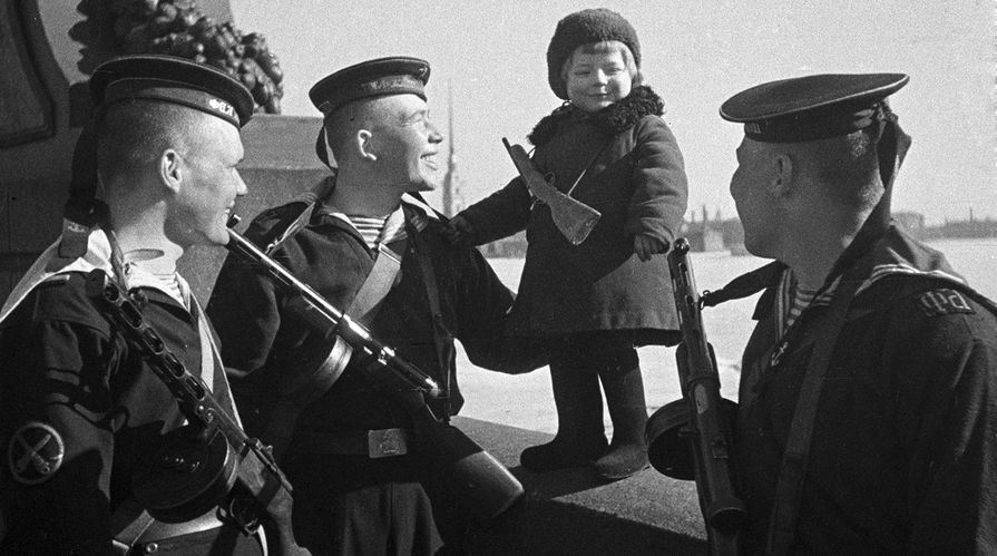 Моряки Балтийского флота с маленькой девочкой Люсей, родители которой умерли в блокаду, май 1943 года