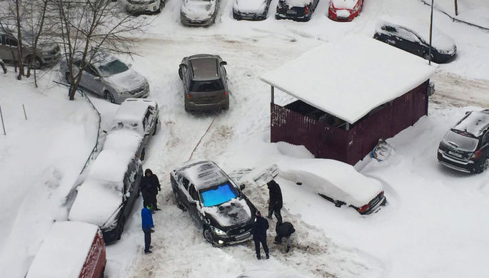 Жители Москвы пытаются вытащить из сугроба автомобиль, 4 февраля 2018 года