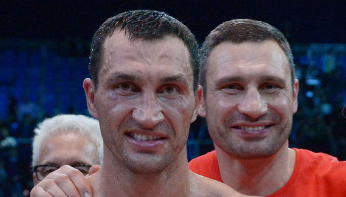 Владимир Кличко радуется победе в бою за титул чемпиона мира по версиям WBA, IBF, WBO и IBO, справа...