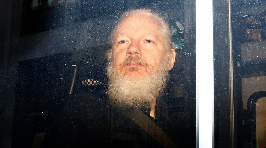 Основатель WikiLeaks Джулиан Ассанж в полицейском автомобиле после ареста в посольстве Эквадора в Лондоне, 11 апреля 2019 года