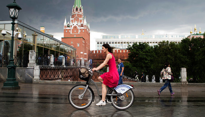 Девушка на велосипеде во время грозы в центре Москвы, июнь 2017 года