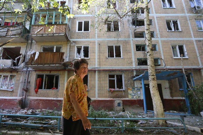 Местная жительница у жилого дома, разрушенного в результате ночного обстрела в Горловке, Донецкая...