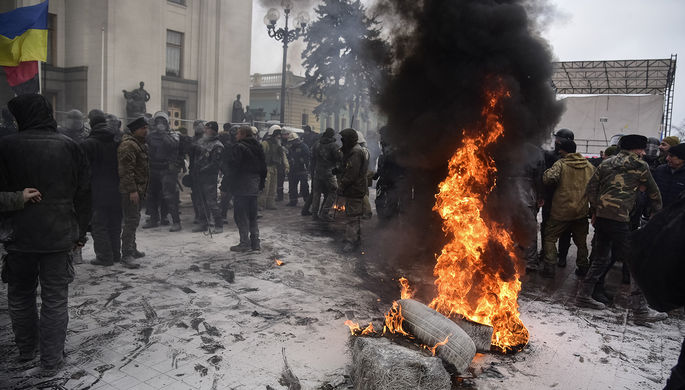 Горящие покрышки во время акции протеста около здания Верховной рады Украины в Киеве, 16 января 2018...