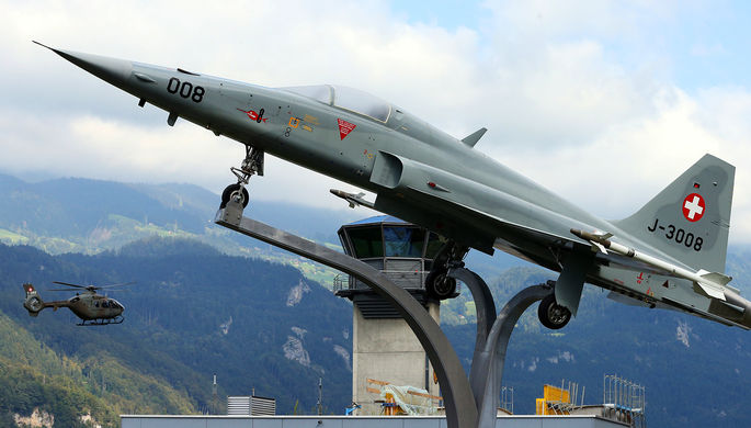 Самолет Northrop F-5 ll «Тайгер» на фоне армейского вертолета около авиабазы...