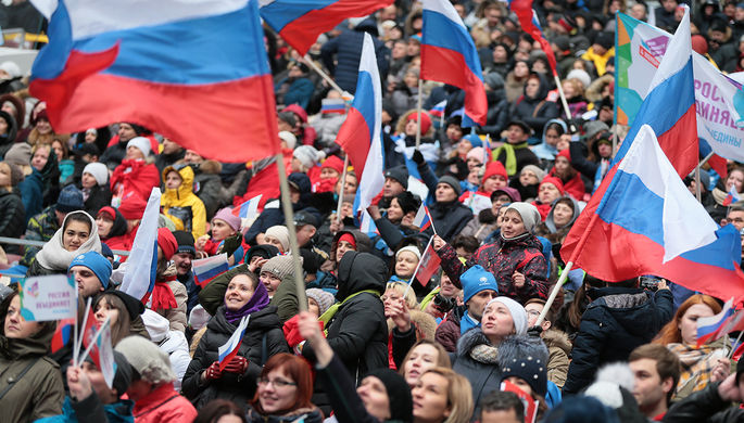 Посетители перед началом митинг-концерта «Россия объединяет!» на большой спортивной...