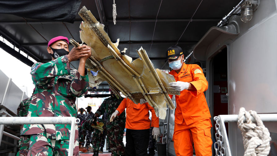  Сотрудники индонезийского ВМФ и спасатели с обломками самолета Boeing 737-500 авиакомпании Sriwijaya... 
