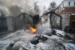 Пожарный тушит горящие автомобильные покрышки, которые подожгли участники акции протеста бойцов батальона «Айдар» и их сторонники у здания министерства обороны Украины в Киеве