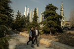 Пара прогуливается по парку на фоне выставки ракет в Тегеране, Иран, 21 января 2024 года