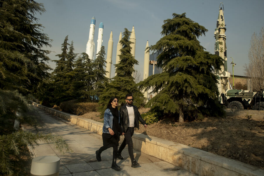 Пара прогуливается по&nbsp;парку на&nbsp;фоне выставки ракет в&nbsp;Тегеране, Иран, 21&nbsp;января 2024&nbsp;года