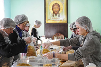 Волонтеры фасуют продукты питания в рамках Всероссийского благотворительного проекта «Народные обеды», организованного банком продовольствия «Русь» и православной службой помощи «Милосердие»