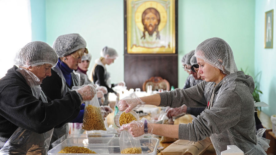 Волонтеры фасуют продукты питания в рамках Всероссийского благотворительного проекта «Народные обеды», организованного банком продовольствия «Русь» и православной службой помощи «Милосердие»