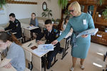 Преподаватель раздает конверты с контрольными измерительными материалами перед началом единого государственного экзамена по математике в средней образовательной школе №41 Челябинска