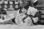Английский модельер Мэри Куант обнимает плюшевого мишку на кровати, украшенной льняным полотном одного из ее последних дизайнов ткани, на презентации продукта в лондонском универмаге 23 февраля 1971 года