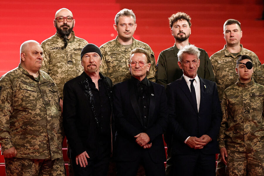 Музыканты Боно, Эдж и актер Шон Пенн с&nbsp;украинскими военнослужащими на&nbsp;красной дорожке Каннского фестиваля перед&nbsp;премьерой документального фильма &laquo;Боно: истории капитуляции&raquo;, 16&nbsp;мая 2025&nbsp;года