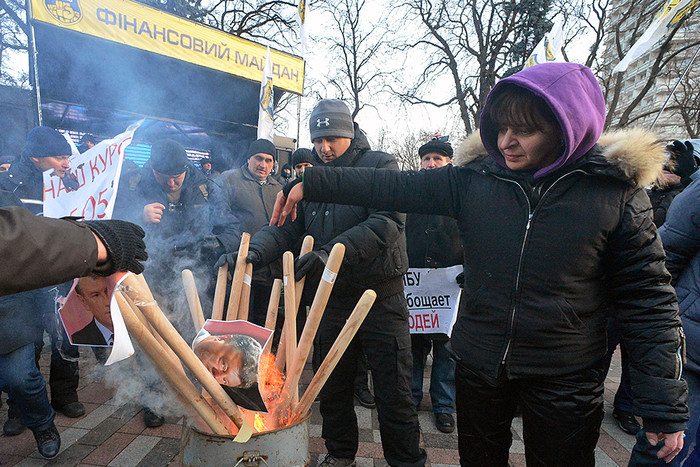 Участники акции протеста «Финансовый майдан» сжигают портрет президента Украины Петра Порошенко у здания Верховной рады Украины