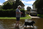 Местный житель выгуливает свою собаку во время наводнения в городе Саут-Уинсор, штат Новый Южный Уэльс, Австралия, 24 марта 2021 года