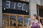 Девушка у здания Центрального телеграфа на Тверской улице в Москве, 26 июня 2022 года