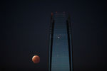 «Кровавая» луна на фоне здания Гран Торре в Сантьяго, Чили, 19 ноября 2021 года