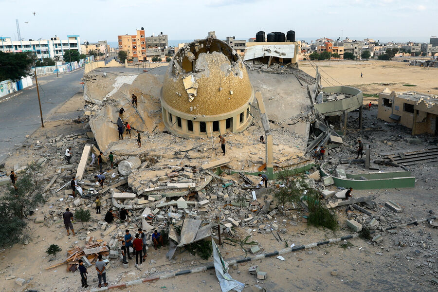 Палестинцы осматривают мечеть, разрушенную в результате израильских ударов в Хан-Юнисе на юге сектора Газа, 8 октября 2023 года