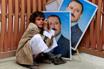 Август, 2011 год. Мальчик сидит у портретов Али Абдаллы Салеха 