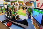 Посетители выставки Gamescom 2011 играют в Nintendo Wii, сидя в гондоле