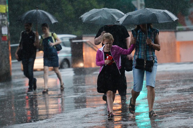 2667410 28.07.2015 Прохожие идут по улице во время сильного дождя в Москве. Кирилл Каллиников/РИА Новости