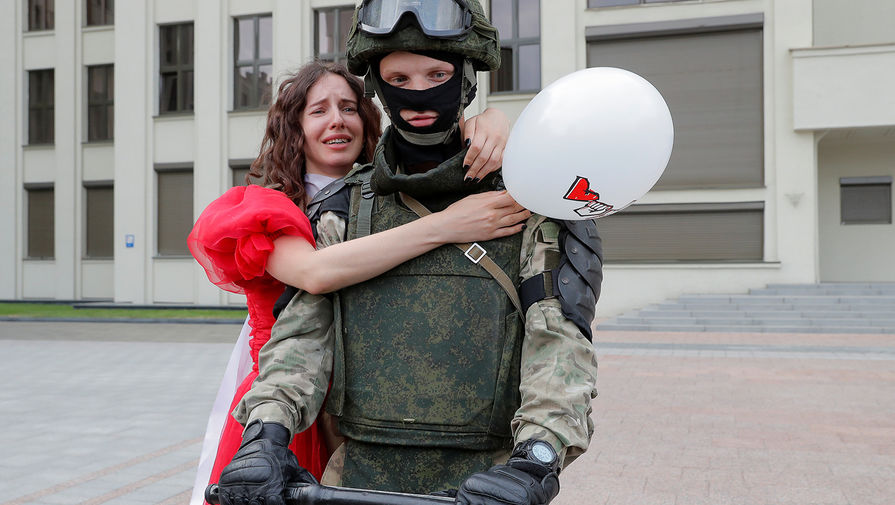 Сотрудник силовых структур Белоруссии и участница демонстрации около Дома правительства в Минске, 14 августа 2020 года