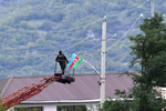 Мужчина устанавливает флаг Азербайджана в одном из населенных пунктов Нагорного Карабаха, 23 сентября 2023 года