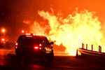 Пожарные борются с огнем в городе Санта-Кларита, который находится в 50 километрах от Лос-Анджелесе, 25 октября 2019 года