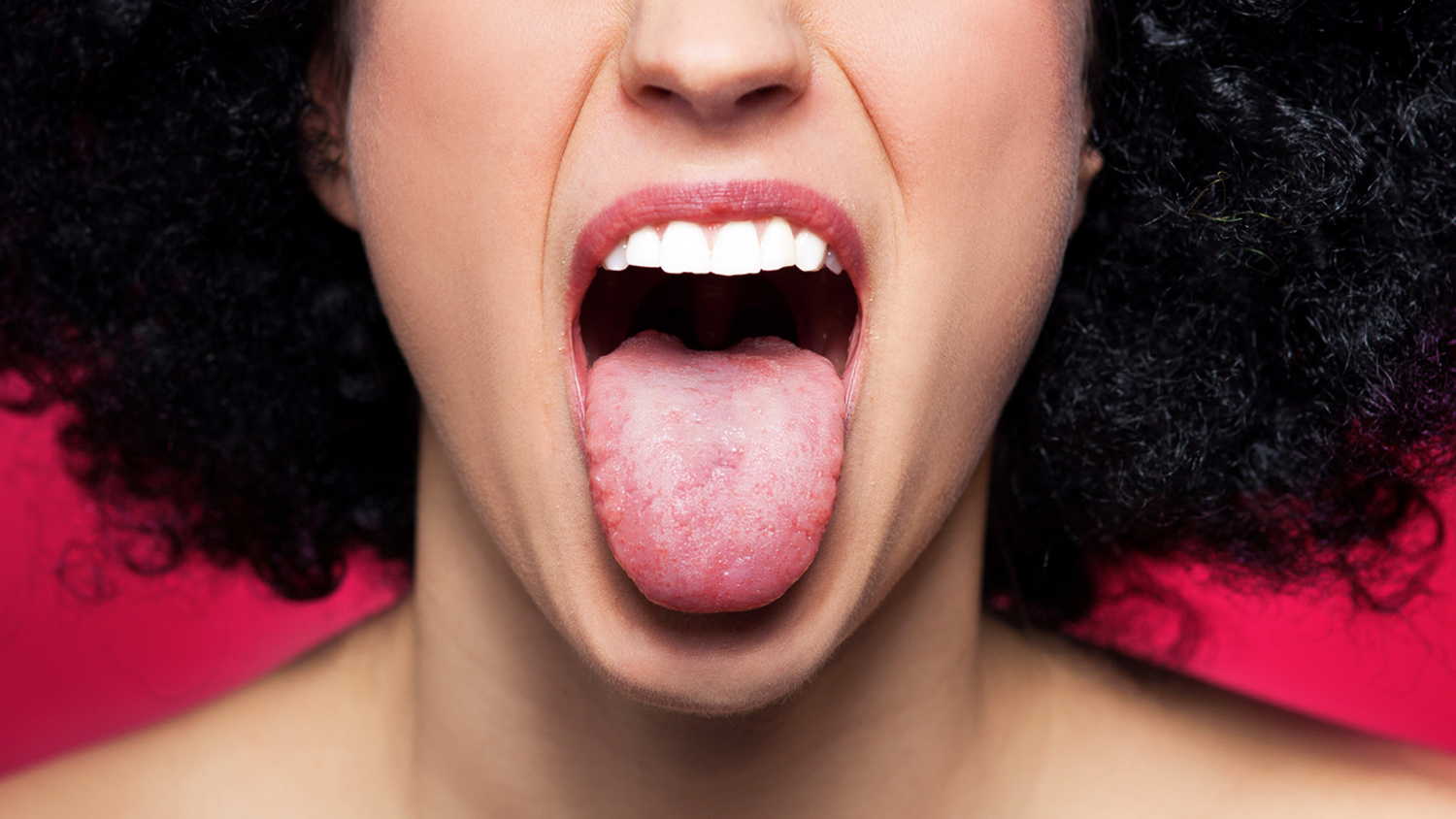 Язык высунутый изо рта. Открытый женский рот. Красивый человеческий язык.