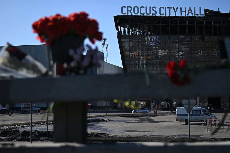 Цветы у стихийного мемориала вдоль дороги у здания концертного зала «Крокус Сити Холл» в память о жертвах теракта, 27 марта 2024 года