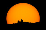 Силуэты туристов на фоне заходящего солнца в парке Папаго в Фениксе, 18 февраля 2023 года