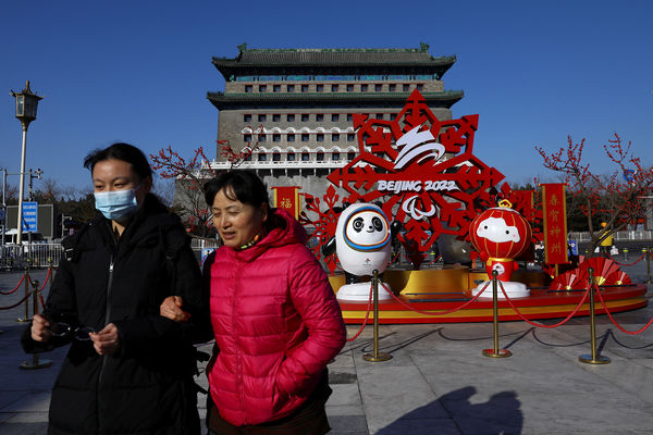 Жители города на фоне официальных маскотов зимней Олимпиады 2022, Пекин, январь 2022 года