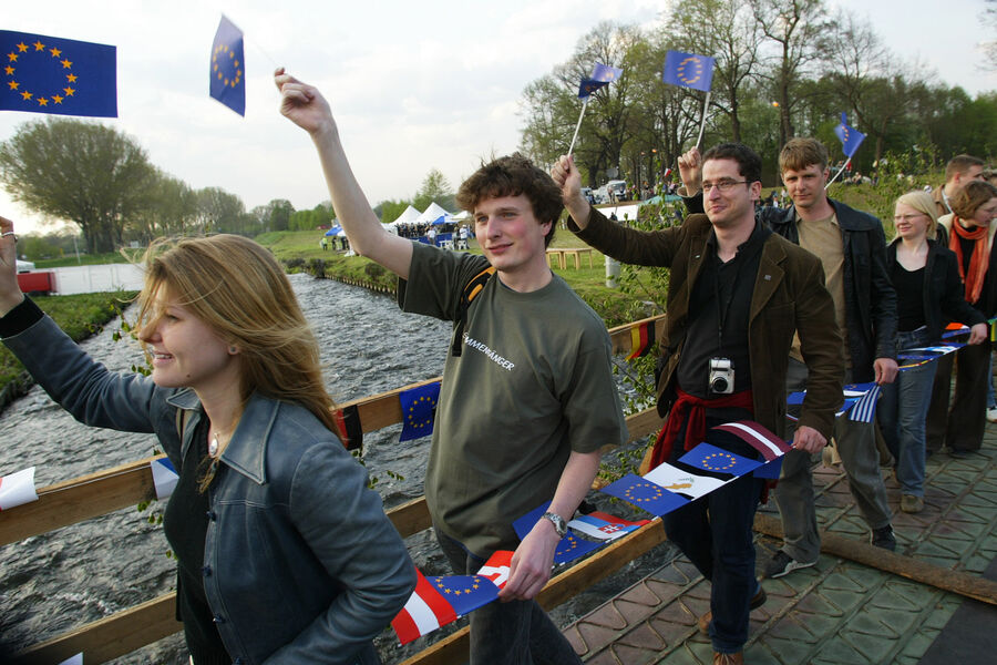 Люди несут флаги ЕС через реку Нейсе, празднуя расширение Евросоюза, Циттау, Германия, 2004 год