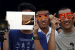 Жители Бангкока наблюдают за солнечным затмением 