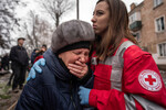Сотрудница «Красного креста» утешает женщину на месте ракетной атаки в Кривом Роге, Украина, 16 декабря 2022 года
