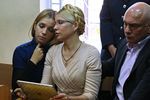 Юлия Тимошенко (в центре) с дочерью Евгенией (слева) и супругом и защитником в суде Александром Тимошенко (справа) в Печерском районном суде Киева. 2011 год