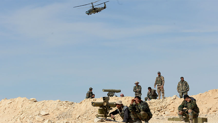 Бойцы сирийской армии (САА) и вертолет Ка-52 &laquo;Аллигатор&raquo; во время боевой операции в&nbsp;окрестностях освобожденного от боевиков города Эль-Карьятейн