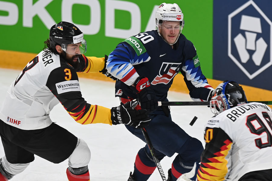 Доминик Биттнер (Германия), Эрик Робинсон (США), вратарь Феликс Брюкман (Германия) в матче чемпионата мира по хоккею — 2021