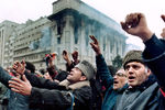 Протестующие против режима перед горящим зданием на площади Республики, 24 декабря 1989 года