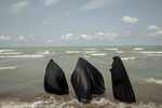 Женщины на берегу Каспийского моря в городе Бабольсер на севере Ирана, 14 июля 2023 года